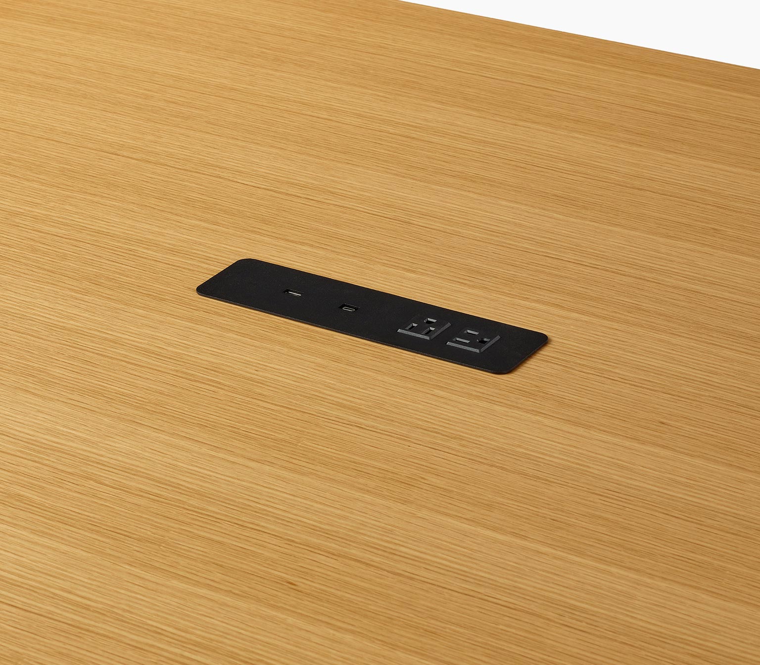 Tabletop power access detail on a counter-height JD Waterfall Table in oak