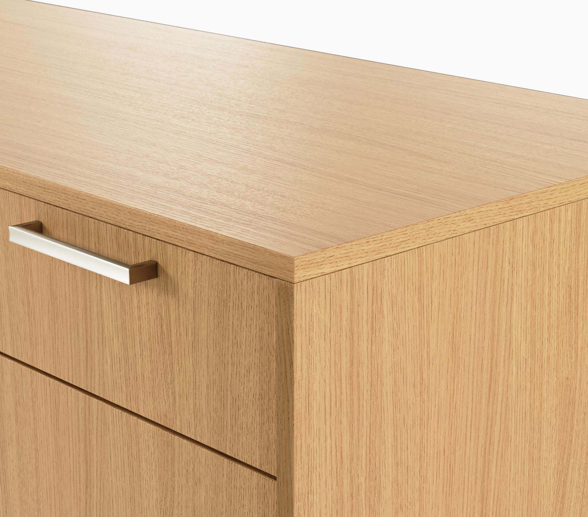 Edge detail on a JD Credenza with one box drawer over a hinged door in natural rift cut oak with satin nickel drawer pulls